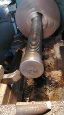 bir torna üzerinde bir basın için bir şaft uzun yuvarlak metal nesnenin torna gerçek closeup vurulur