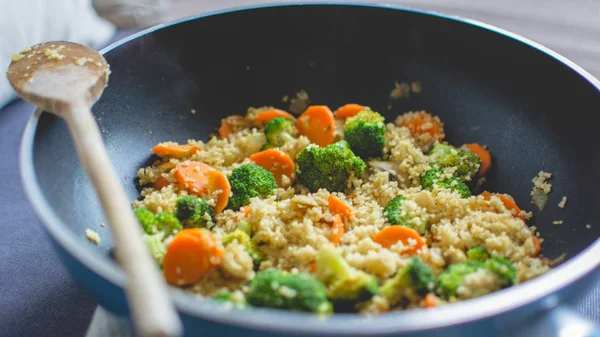 Cooking quinoa with vegetables, broccoli and carrots