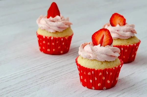 Cupcakes with strawberry decoration on a white wooden background — Stock Photo, Image