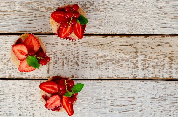 Nahaufnahme Muffins dekoriert frische Erdbeere auf alten weißen Holztischhintergrund. — Stockfoto