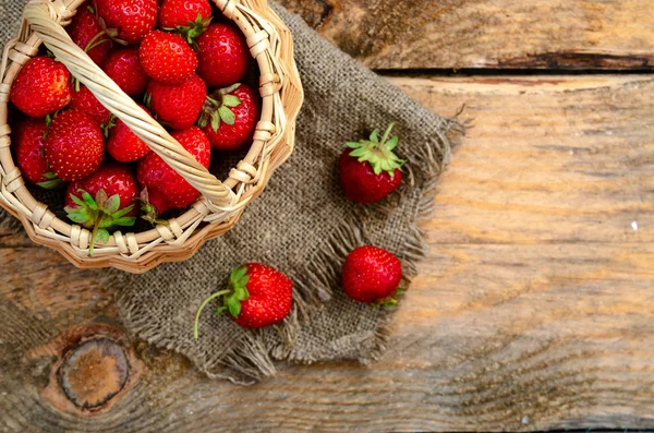 Frisch gereifte Erdbeeren im Korb voll isoliert auf Holz — Stockfoto