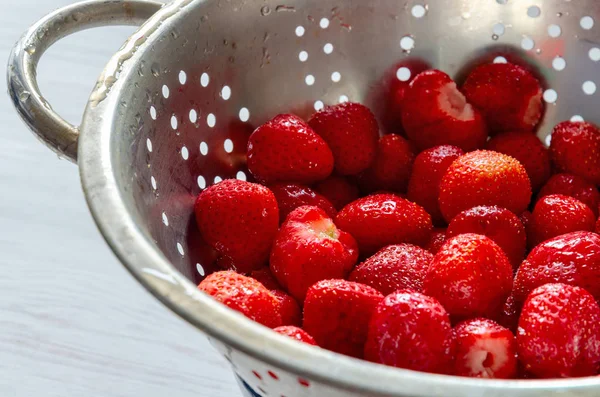 Frische rote Erdbeeren in Edelstahl-Sieb weißen Holzhintergrund — Stockfoto