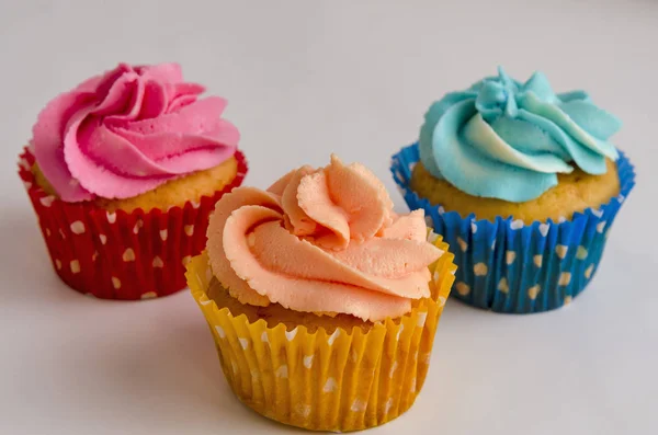 Os cupcakes caseiros coloridos em um fundo branco — Fotografia de Stock