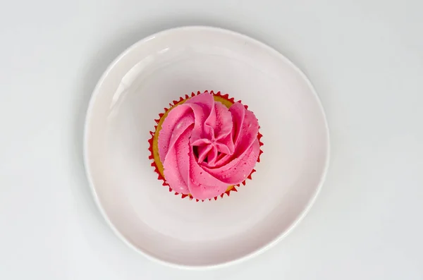 Rosa Cupcake auf einem Teller isoliert auf weißem Hintergrund. leckerer Kuchen. Ansicht von oben. — Stockfoto