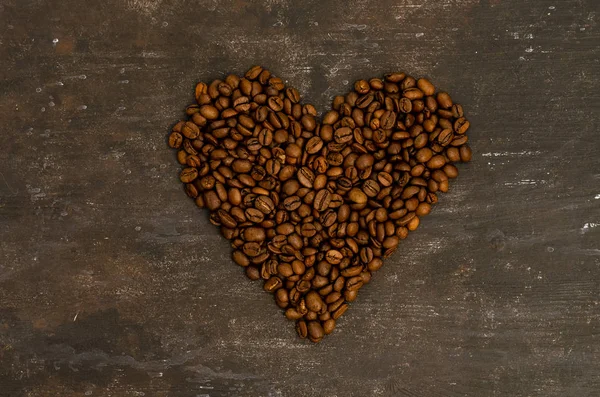 Кофе в бобах на темном фоне. Кофейные зерна в форме сердца. Текстура абстрактного фона. Фон питания кофейных зерен — стоковое фото