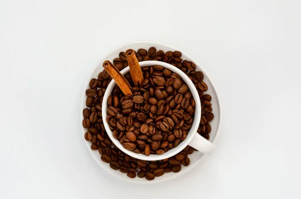 Кофейная чашка с жареными кофейными зёрнами на белом. Вид сверху — стоковое фото