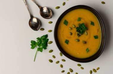 Beyaz arka planda kabak çekirdeği ile kabak çorbası. üst görünüm