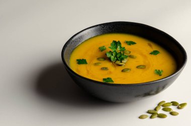 Beyaz arka plan üzerinde izole krem ve kabak çekirdeği kabak çorbası