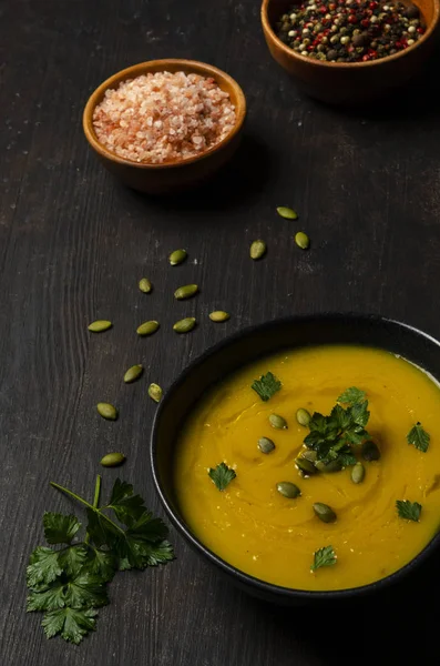 Ahşap arka plan üzerinde krem ve kabak çekirdeği ile kabak kremalı çorba