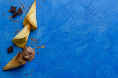 Mavi ahşap arka plan üzerinde dondurma için geleneksel waffle konileri. Yaz, açık alan gofret ve masanın üzerinde çerçeve içinde çikolata cips.