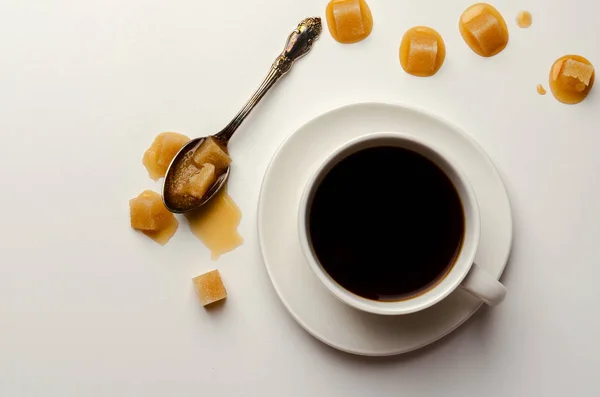 Кофейная чашка вид сверху на белом фоне с ложкой расплавленного сахара — стоковое фото