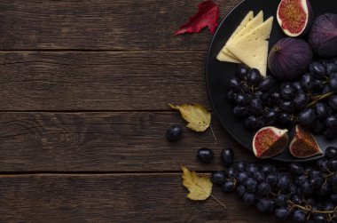 incir ile peynir, koyu ahşap yuvarlak tahta üzerinde üzüm, siyah arka plan, lezzetleri, üst görünüm düz yatıyordu kopya alanı