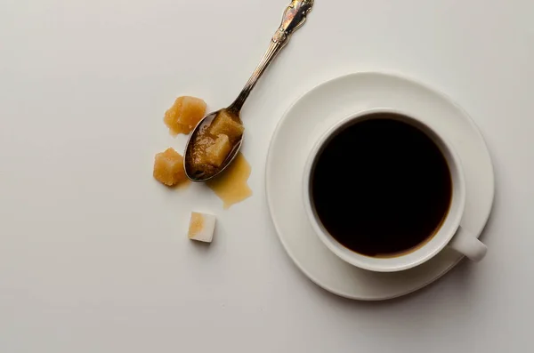 Copa de café vista superior sobre fondo blanco con cuchara de azúcar derretida — Foto de Stock