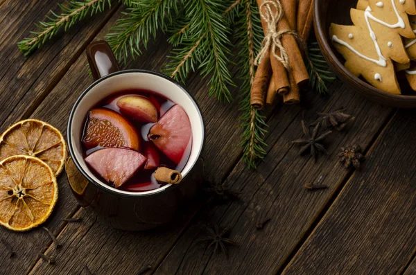 Κύπελλο Χριστουγεννιάτικου κρασιού ή γκλούβαιν με μπαχαρικά και φέτες πορτοκαλιού σε ρουστίκ ξύλινη θέα στην κορυφή του τραπεζιού. Παραδοσιακό ποτό τις χειμερινές διακοπές. — Φωτογραφία Αρχείου