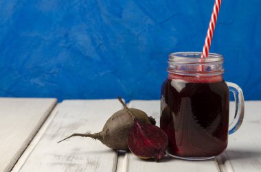 Beyaz ahşap arka plan üzerinde bir kavanozsağlıklı pancar yüzlü