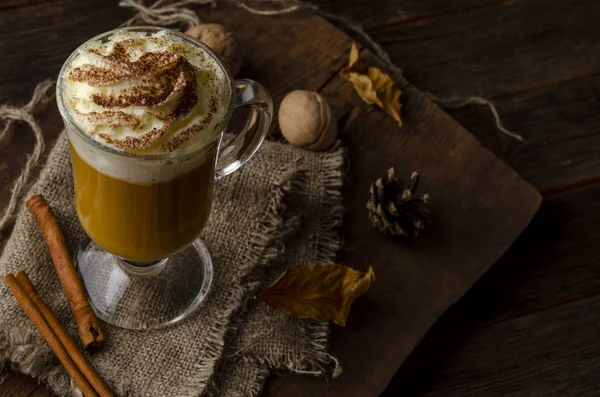 Græskar latte med flødeskum i en glaskrukke på en rustik baggrund - Stock-foto