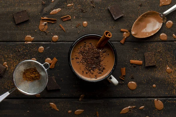Filiżanka gorącej czekolady na czarnych drewnianych deskach z kroplami czekolady, kakao — Zdjęcie stockowe