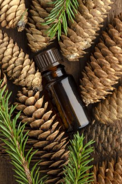 Ahşap zemin üzerinde çam kozalaklı köknar ağacı yağı şişesi