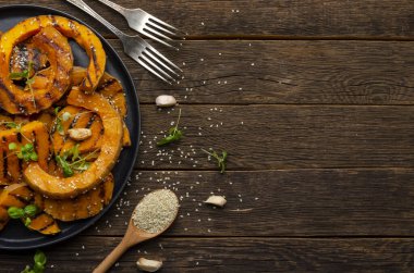 Eski ahşap arka planda kavrulmuş balkabağı dilimleri. Sağlıklı vejetaryen yemeği..