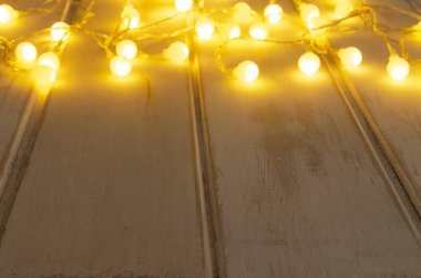 Noel ışıklandırması arka planı. Büyük ışıklar. Beyaz tahtalarda Noel gerdanlığı.