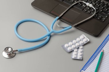 Teletıp ya da tele-sağlık, uzaktan doktor görüntülü sohbet konsepti, dizüstü bilgisayar ve stetoskop gri üzerine
