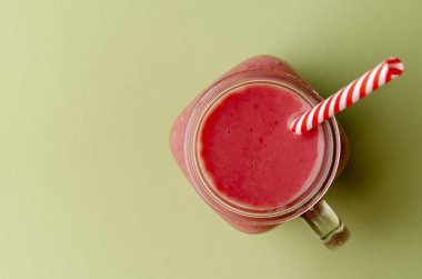 Kavanoz bardakta pembe çilekli smoothie.