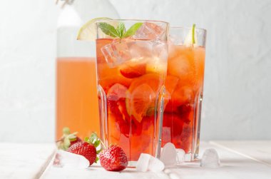 Limonlu çilekli mojito ve beyaz ahşap arka planda nane.