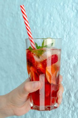 Çilekli mojito, limonlu ve nane arkaplanda kadın eli.