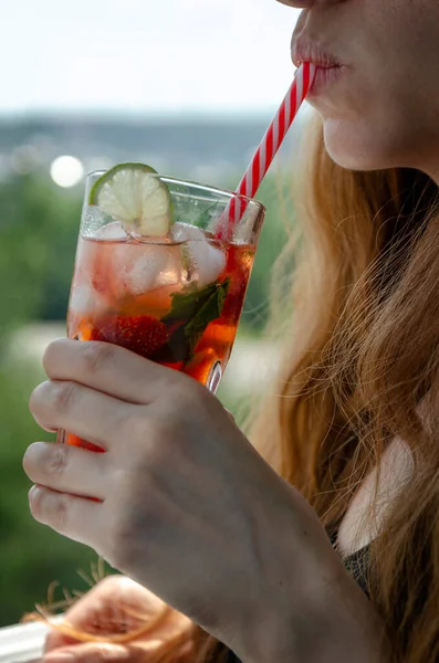 Jeune femme sur le balcon boit froid fraise fraîche mojito — Photo