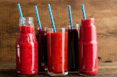 Farklı meyve sularıyla taze cam kavanozlar.