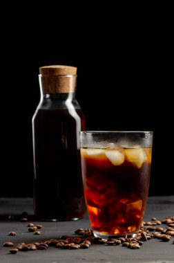 Bir bardak ve bir kavanoz filtre kahve, koyu bir kahve.