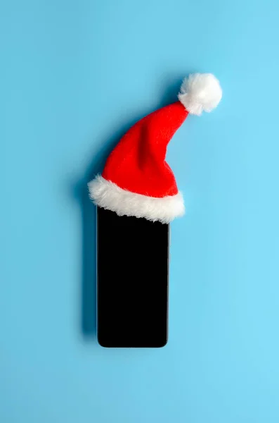スマートフォンでクリスマスの帽子上の青 — ストック写真