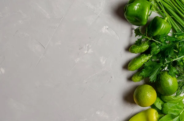 Gri arka planda çiftlik yeşili sebzeler. Üst görünüm.