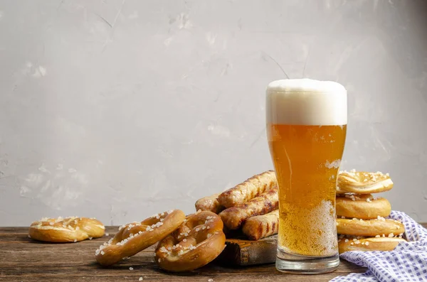 Oktoberfest food, bavarian pretzels with beer glass on old rustic wooden background