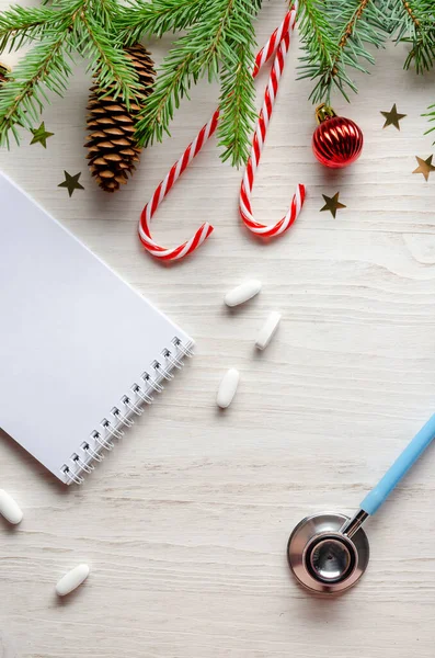 健康産業でクリスマスを祝う。平置きだ。白い背景にクリスマスの装飾が施された聴診器. — ストック写真