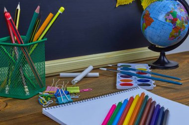 Okul konseptine geri dönelim. Sarı kestane yaprakları ile bir tahta arka plan üzerinde ahşap bir masa üzerinde Okul malzemeleri.