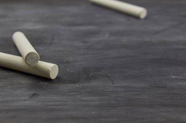 Okul konseptine geri dönelim. Metin için kopyalama alanı ile siyah boş tebeşir tahtası üzerinde tebeşir parçaları