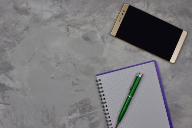 Metin için kopya alanı ile mermer arka plan için not defteri, kalem ve cep telefonunun görünümünü kapatın. Ofis konsepti