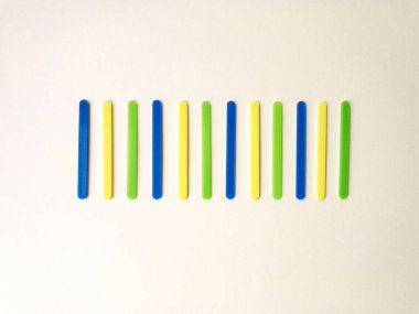 Açık sarı arka plan üzerinde saymak için öğrenme için matematiksel işlemleri hesaplamak için renkli sayma sopalar. Okul konseptine geri dönelim. Kopyalama alanı