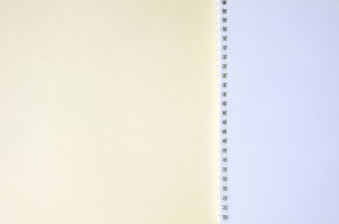 Açık sarı arka plan üzerinde spiral bağlayıcı ve boş sayfalar ile kağıt not defteri üst görünümü. İş veya eğitim kavramı, metniniz için kopya alanı