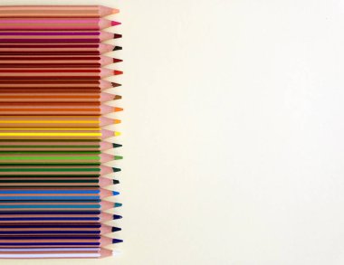 Açık sarı arka plan üzerinde izole kopya alanı ile yatay renkli kalemler. Eğitim çerçeve konsepti, afiş, davetiye için kullanılabilir