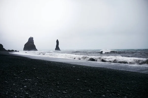 Reynisfjara Kara Kum Sahili 'nin doğusunda Deniz Yığınları ve Basalt Clifs, Güney İzlanda' da Vik..