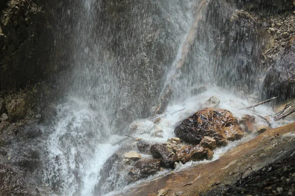 Розщеплення води на каменях від падаючого водоспаду — стокове фото