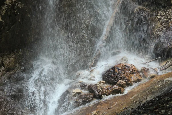 Spruzzare acqua sulle rocce da una cascata che cade — Foto Stock