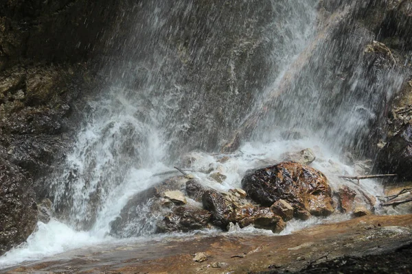 Spruzzare acqua sulle rocce da una cascata che cade — Foto Stock