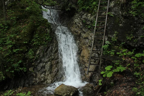 Dangerous trail through a waterfall with steel ladders in the Sl — Stock Photo, Image