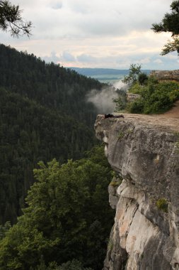 Bir adam, abyss'in hemen üstündeki çıkıntıda duruyor.