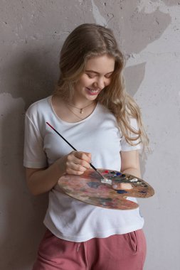 Paletüzerinde fırça karıştırma renkleri ile genç güzel kız. Sanat, yaratıcılık, hobi konsepti.