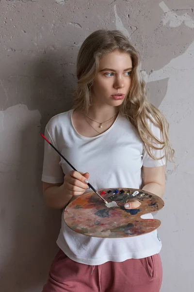 Młoda Ładna Blondynka z pędzlem mieszania kolorów na palecie. Sztuka, kreatywność, koncepcja hobby. — Zdjęcie stockowe