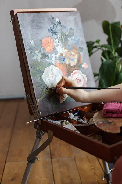 Bir easel üzerinde fırça boyama çiçekler resmi ile sanatçı ellerini kapatın. Sanat, yaratıcılık, hobi konsepti. — Stok fotoğraf